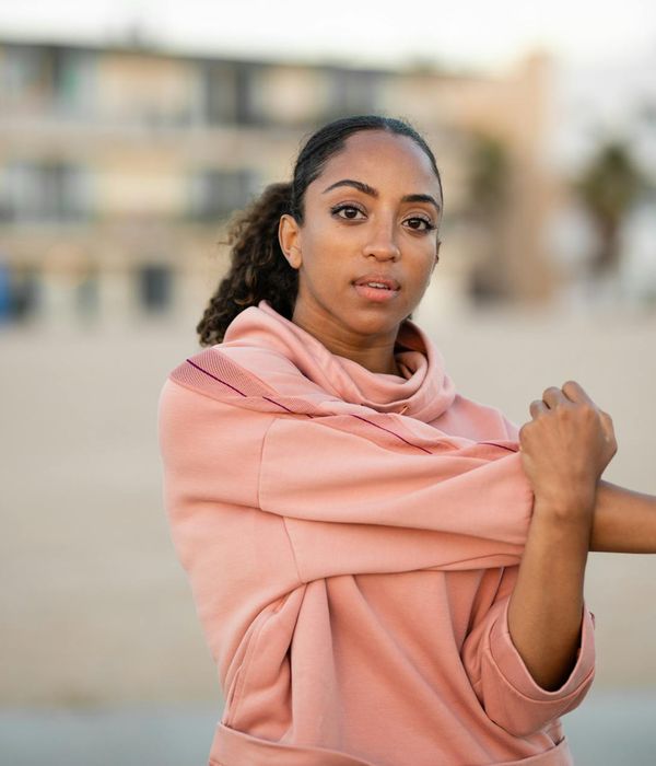 Woman stretching gracefully outdoors, feeling vibrant and full of life.